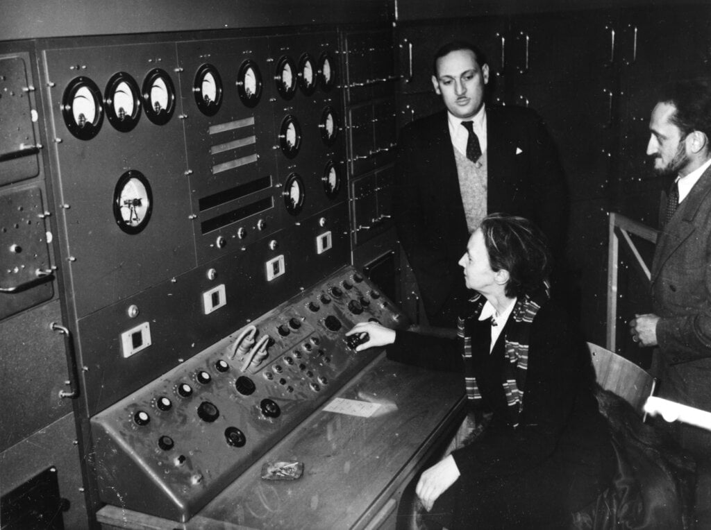 A man and a woman in front of a control panel