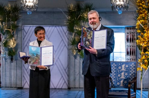 Peace laureates Maria Ressa and Dmitry Muratov showing their Nobel Prize diplomas