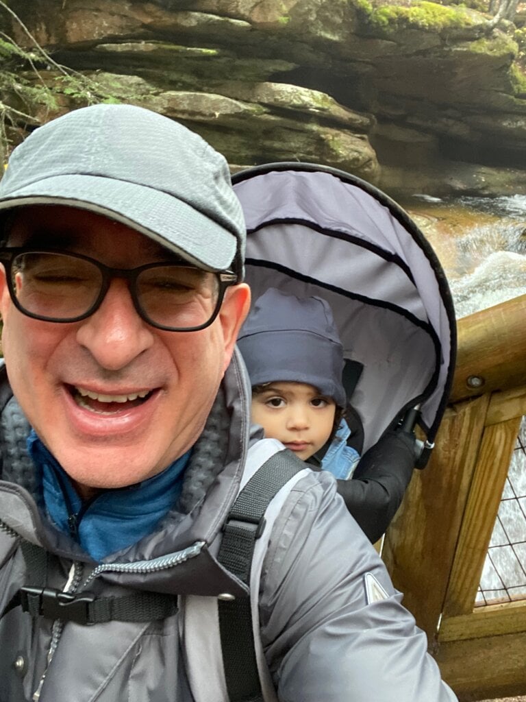 A selfie of Joshua Angrist with his grandchild in a backpack out walking