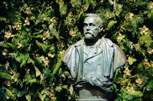 A statue with flower decorations behind it