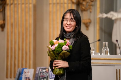 Awoman holding a bunch of flowers