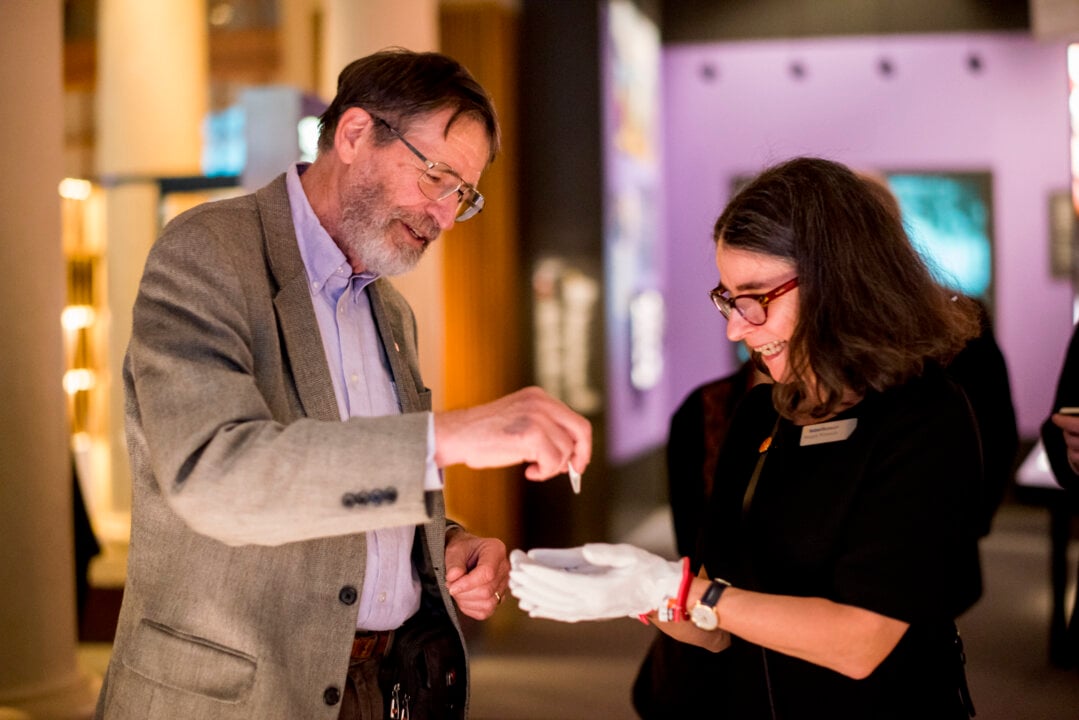 A man donates an object to a museum