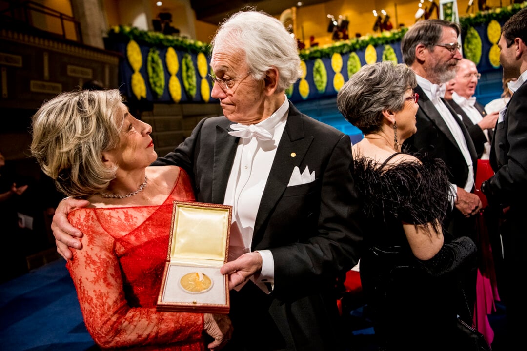 A man and a woman showing a medal
