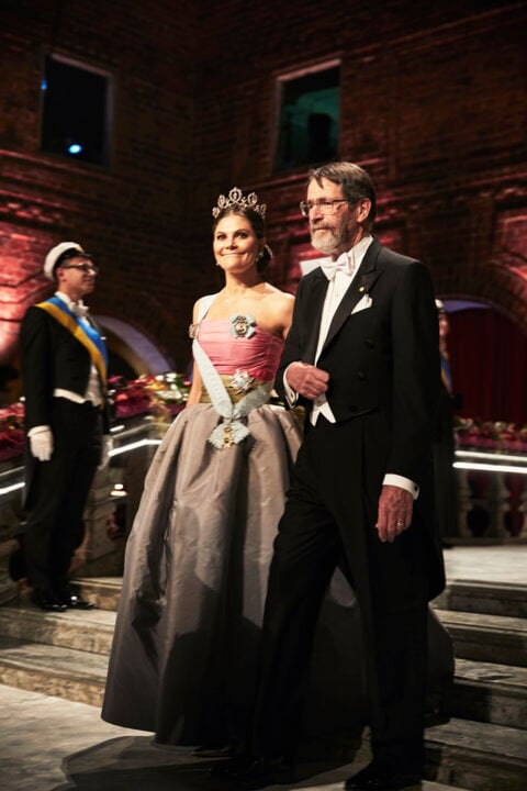 A man and a woman proceeding down stairs