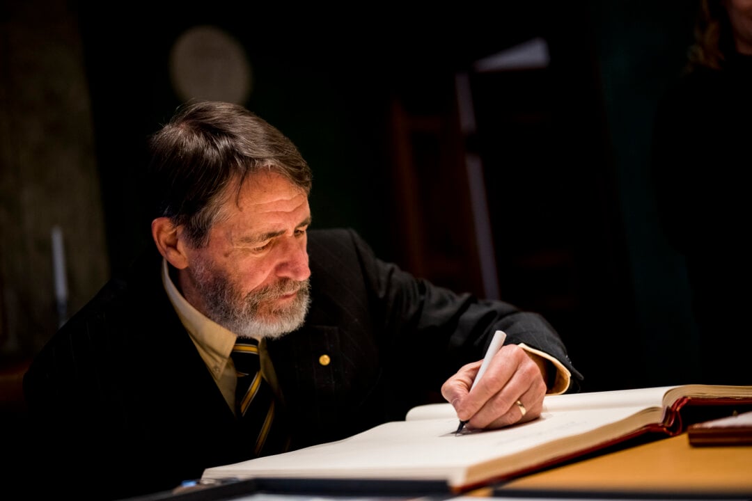 A man signs a guest book
