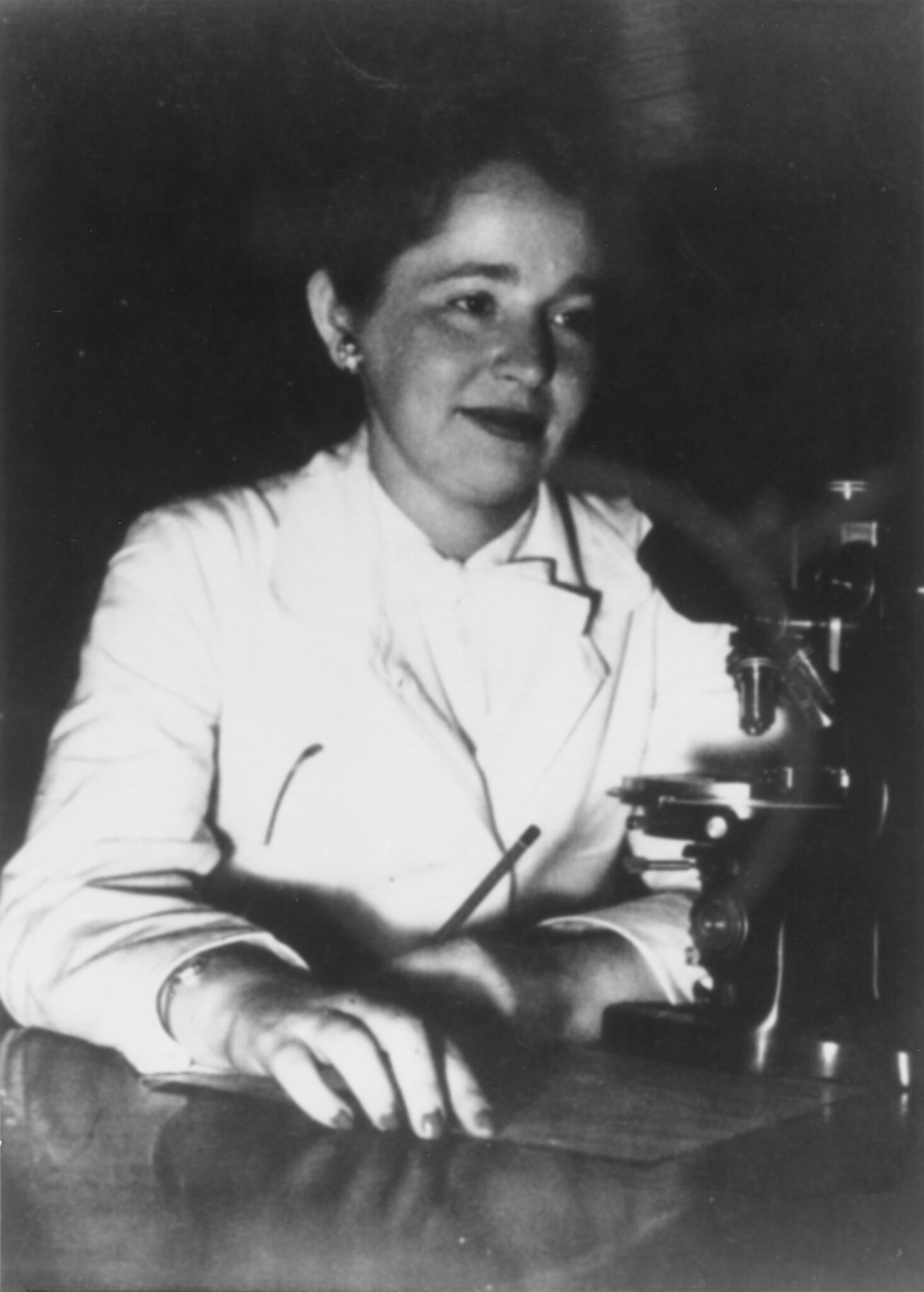A woman in front of a microscope
