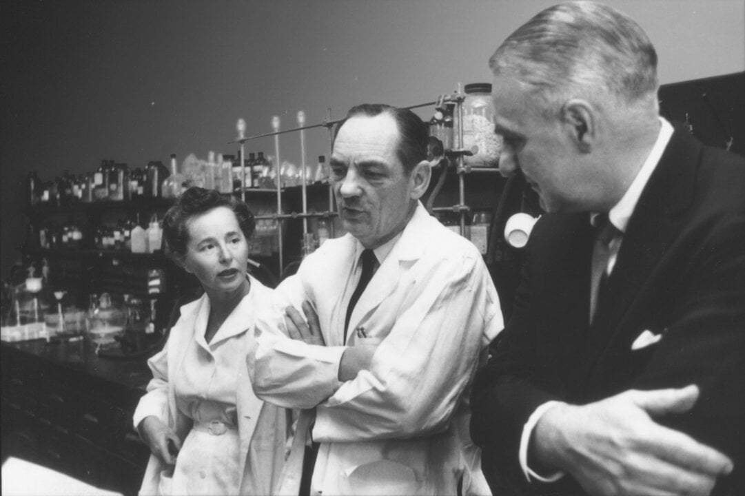 A woman and two men discussing in a laboratory