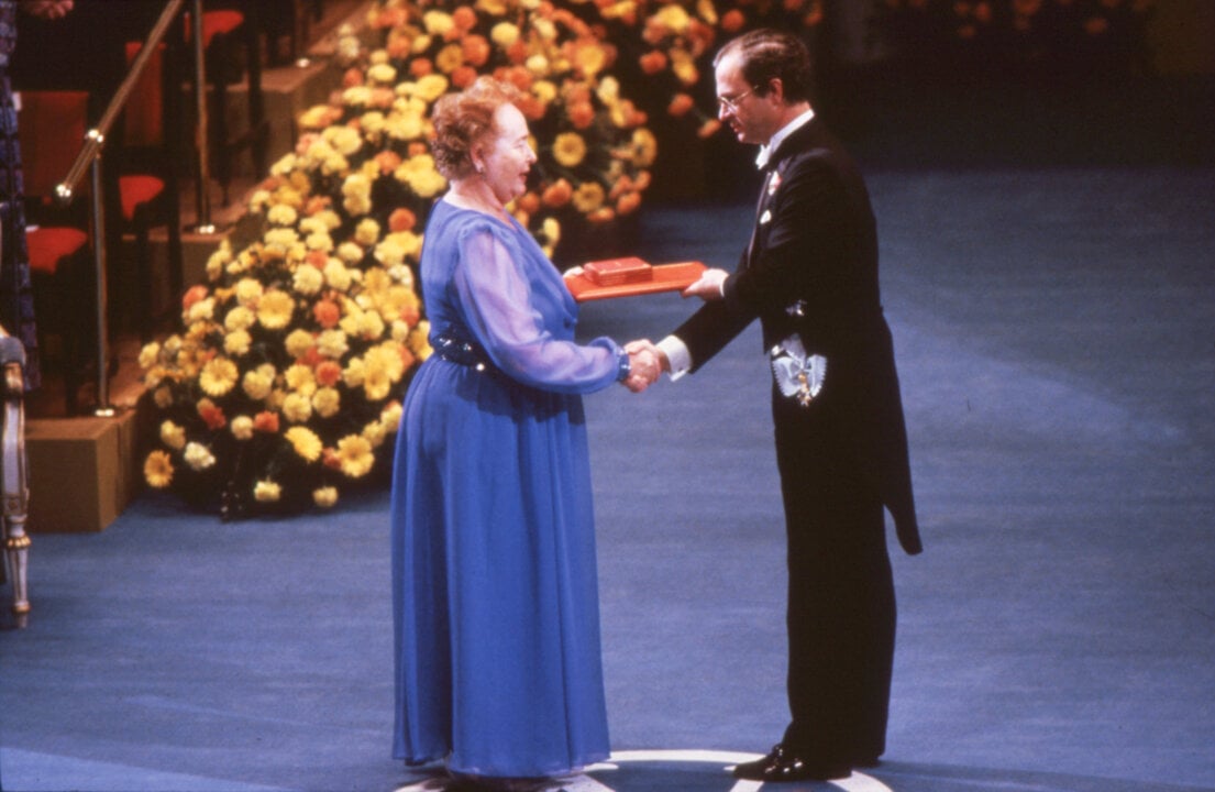 A woman is awarded a prize from a king