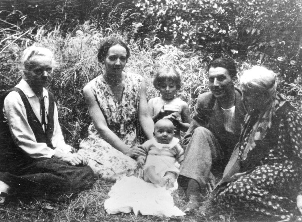 A famile seated in the grass