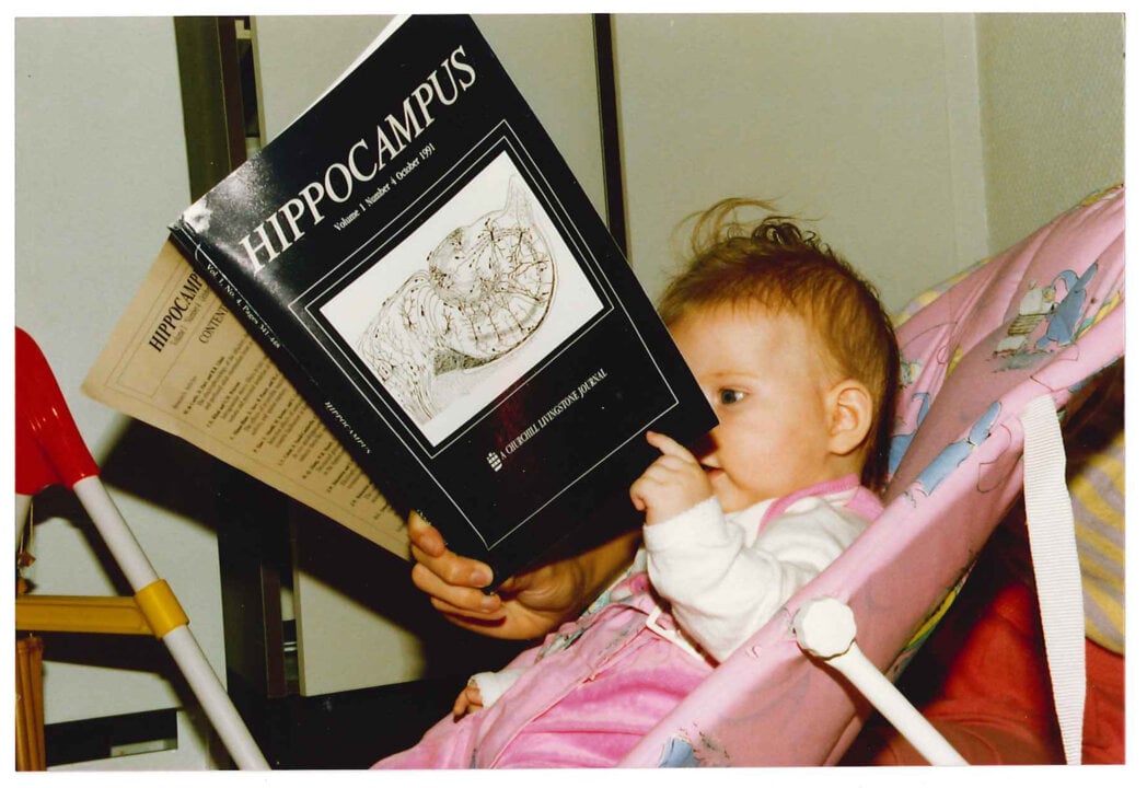 A baby girl reading a book