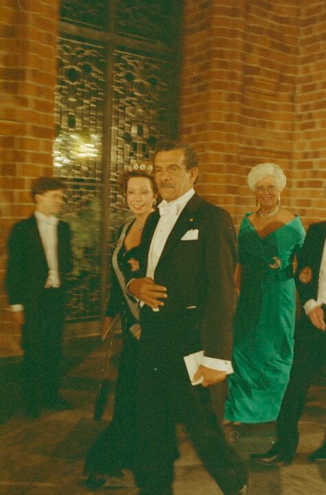 A man and a woman proceeds in a big hall