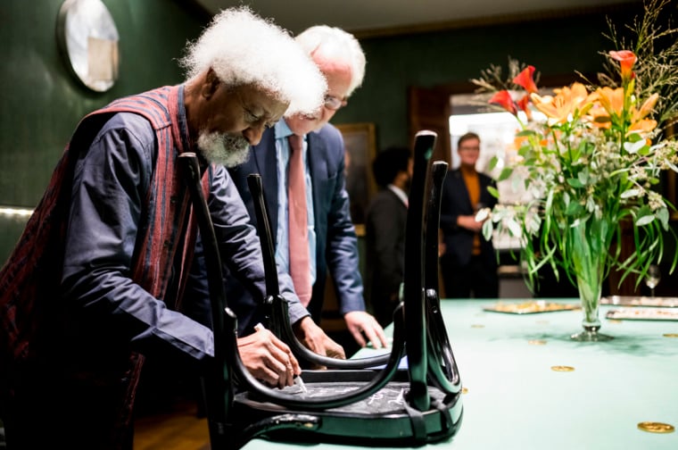 Wole Soyinka autographs a chair for the Nobel Prize Museum